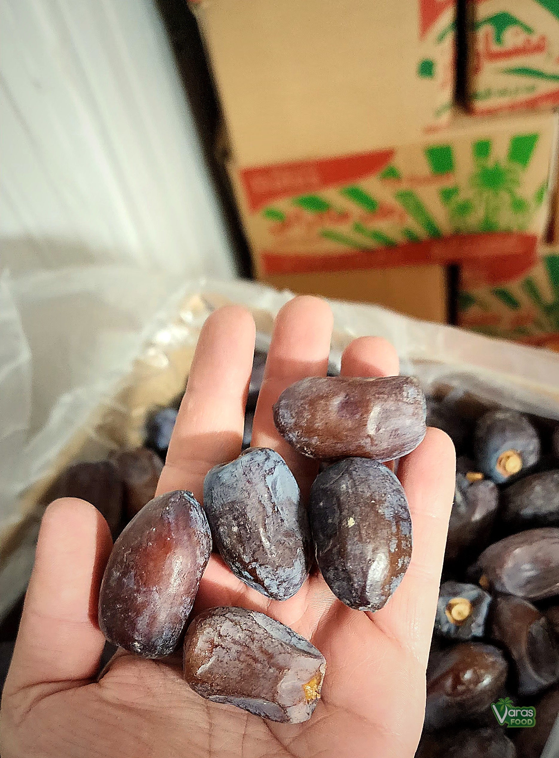 Hand holding VARAS Food Kaluteh dates
